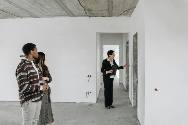 A couple explores an unfinished apartment with a real estate agent, considering property purchase options.